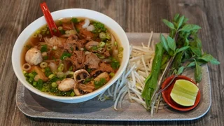 Bowl of vegan pho (Pho Noodle Soup) with rice noodles, vegan chicken and beef, mushrooms and tofu at Saigon Vegan in Garden Grove, CA